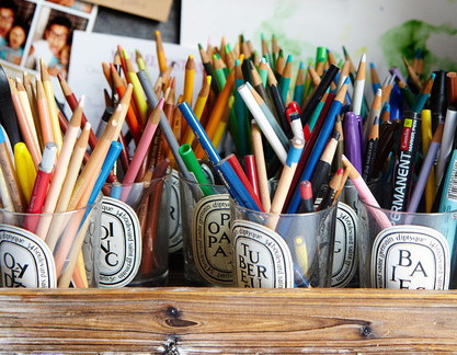 Fill an old candle jar with crafting supplies.