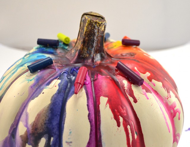 Melt crayons on a pumpkin for a colorful Halloween decoration.
